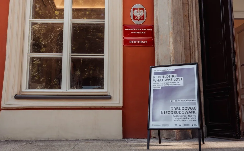 Wejście do Akademii Sztuk Pięknych w Warszawie, przed wejściem informacja o konferencji "Odbudować nieodbudowane"